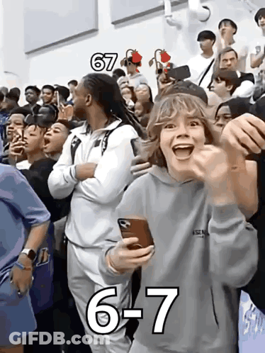 A Group Of People Are Watching A Game And One Of Them Is Wearing A Hoodie That Says Essentials On It GIF