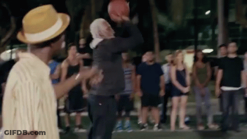 A Group Of People Are Watching A Man Throw A Basketball GIF