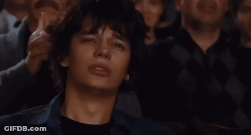 A Group Of People Are Watching A Movie And One Of Them Is Making A Funny Face GIF