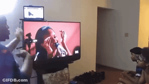 A Group Of People Are Watching A Video On A Flat Screen Television GIF
