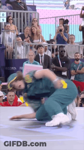 A Group Of People Are Watching A Wrestling Match With The Number 9 On The Screen GIF
