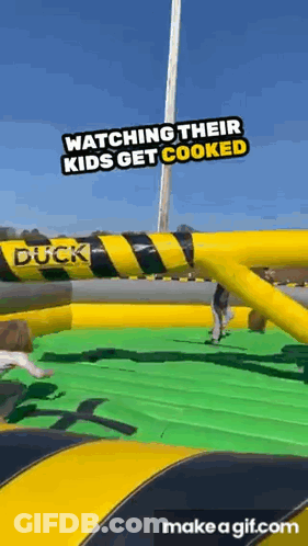 A Group Of People Are Watching Their Kids Get Cooked At An Inflatable Duck . GIF