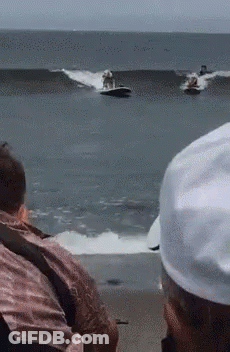 A Group Of People Are Watching Two Jet Skis Racing In The Ocean GIF