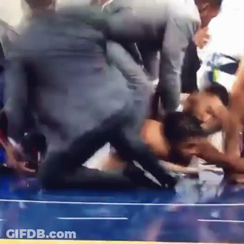 A Group Of People Are Wrestling On A Blue Wrestling Mat GIF