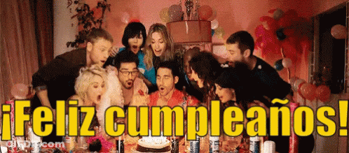 A Group Of People Blowing Out Candles On A Birthday Cake With The Words Feliz Cumpleanos In The Background GIF