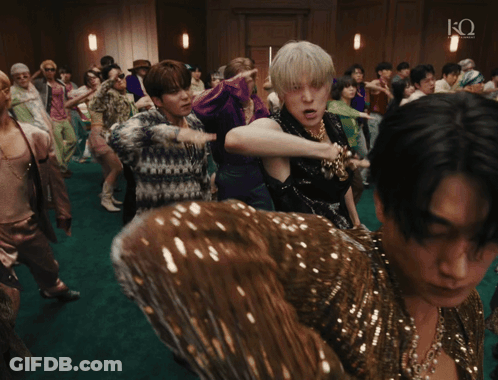 A Group Of People Dancing In A Room With The Letter Q On The Bottom Right GIF