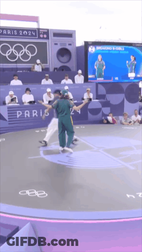 A Group Of People Dancing In Front Of A Paris 2024 Sign GIF