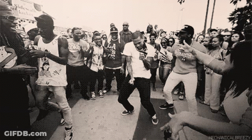 A Group Of People Dancing In Front Of A Sign That Says Mechanicalbreezezy GIF