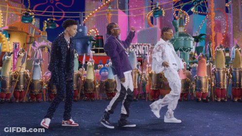 A Group Of People Dancing In Front Of A Sign That Says Spongebob Squarepants GIF