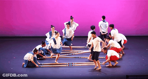 A Group Of People Dancing On A Stage With A Pink Backdrop GIF