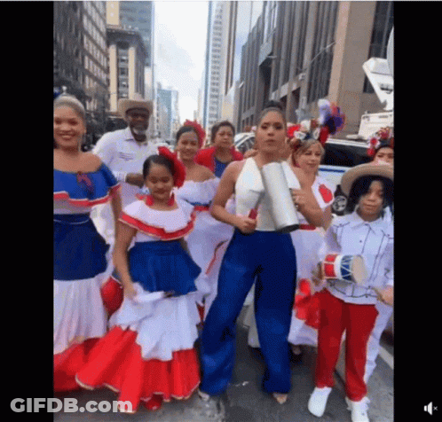 A Group Of People Dressed In Red White And Blue Standing On A Street GIF