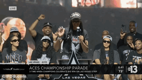 A Group Of People Gathered Around A Podium With The Words Aces Championship Parade On The Bottom GIF