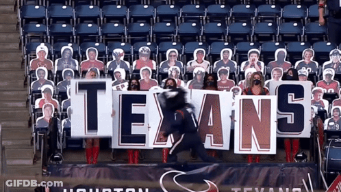 A Group Of People Holding A Texans Sign In A Stadium GIF
