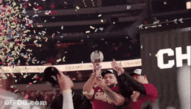A Group Of People Holding A Trophy In Front Of A Banner That Says Champion GIF