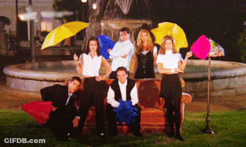 A Group Of People Holding Umbrellas Are Posing For A Picture In Front Of A Fountain GIF