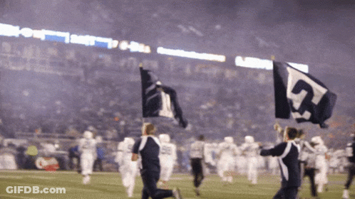 A Group Of People Holding Up Flags With The Number 5 On Them GIF