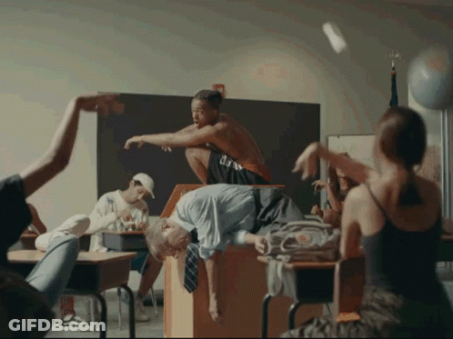 A Group Of People In A Classroom With One Wearing A Shirt That Says ' U.s.a. ' On It GIF