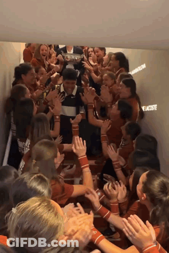 A Group Of People In A Hallway With The Word Lacoste Written On The Wall GIF