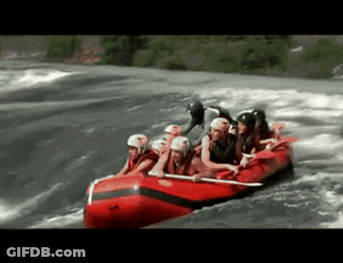 A Group Of People In A Red Raft Going Through A River GIF