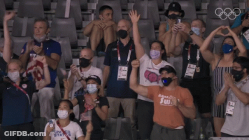 A Group Of People In A Stadium Wearing Face Masks And Shirts That Say Swt GIF