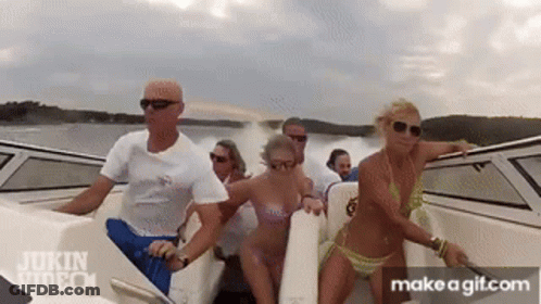 A Group Of People In Bikinis Are Riding A Boat In The Water . GIF