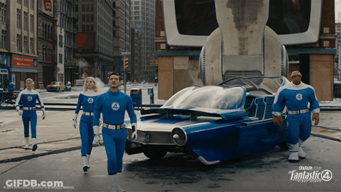 A Group Of People In Fantastic 4 Costumes Are Walking Down A Street GIF