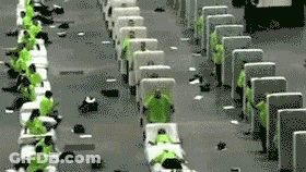 A Group Of People In Green Shirts Are Sitting In A Row Of Chairs . GIF