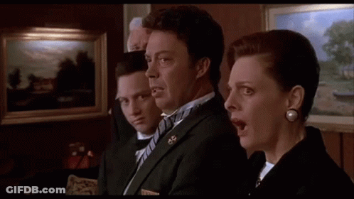 A Group Of People In Suits And Bow Ties Are Standing Next To Each Other In A Room With Their Mouths Open . GIF