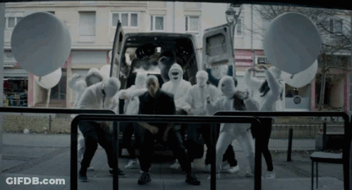 A Group Of People In White Masks Are Dancing In Front Of A White Van GIF