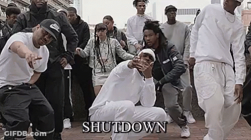 A Group Of People In White Shirts Are Dancing On A Sidewalk . GIF