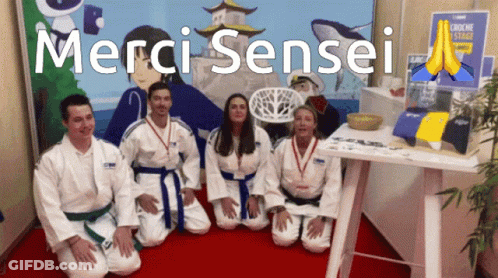 A Group Of People Kneeling In Front Of A Sign That Says Merci Sensei On It GIF