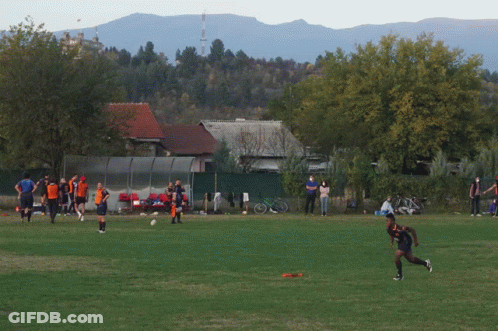 A Group Of People On A Field With One Wearing A Blue Shirt That Says ' Soccer ' On It GIF