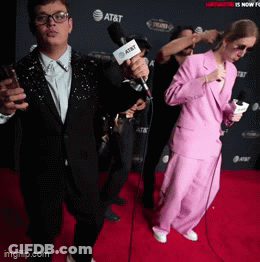 A Group Of People On A Red Carpet With At & T In The Background GIF