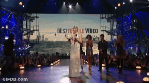 A Group Of People On A Stage With The Words Best Festival Video On The Screen Behind Them GIF