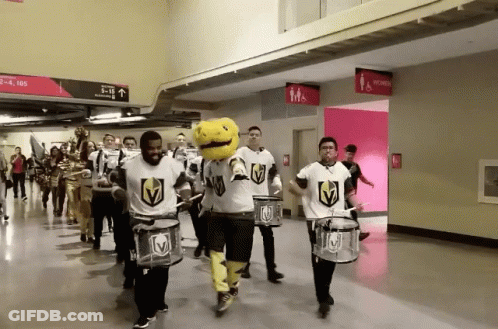 A Group Of People Playing Drums In A Hallway With A Sign That Says Men 'S And Women 'S Restrooms GIF