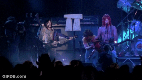 A Group Of People Playing Instruments On A Stage With Marshall Amps In The Background GIF