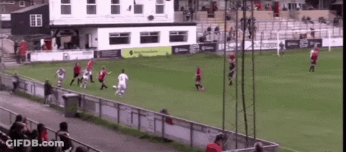 A Group Of People Playing Soccer On A Field With A Building In The Background That Says ' Kappa ' GIF
