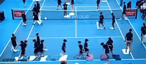 A Group Of People Playing Tennis On A Blue Court With Emirates Advertisements GIF