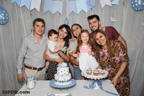 A Group Of People Pose In Front Of A Cake And Cupcakes GIF
