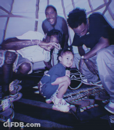 A Group Of People Posing For A Photo With A Little Girl In The Middle GIF