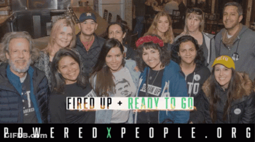 A Group Of People Posing For A Photo With The Words Fired Up + Ready To Go Behind Them GIF