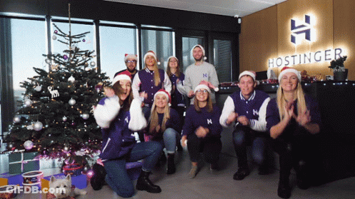 A Group Of People Posing For A Picture In Front Of A Hostinger Logo GIF