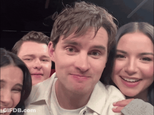 A Group Of People Posing For A Picture With A Man Holding A Piece Of Paper That Says ' I Love You ' GIF