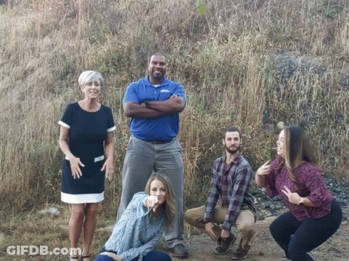 A Group Of People Posing For A Picture With One Man Wearing A Shirt That Says ' A & A ' GIF
