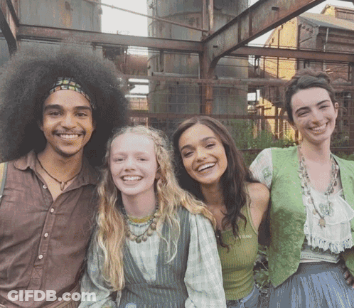 A Group Of People Posing For A Picture With One Of Them Wearing A Green Vest GIF