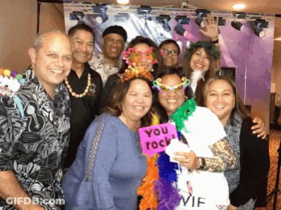 A Group Of People Posing For A Picture With One Woman Holding A Sign That Says " You Rock " GIF