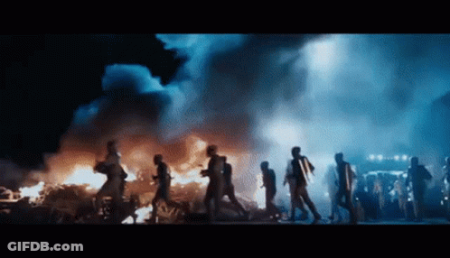 People Running In Front Of Large Fire GIF
