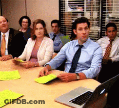 A Group Of People Sit Around A Table With A Laptop GIF