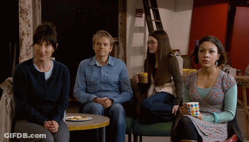 A Group Of People Sitting Around A Table With A Plate Of Food On It GIF