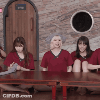 A Group Of People Sitting Around A Table With A Sign On The Wall That Says ' A ' On It GIF